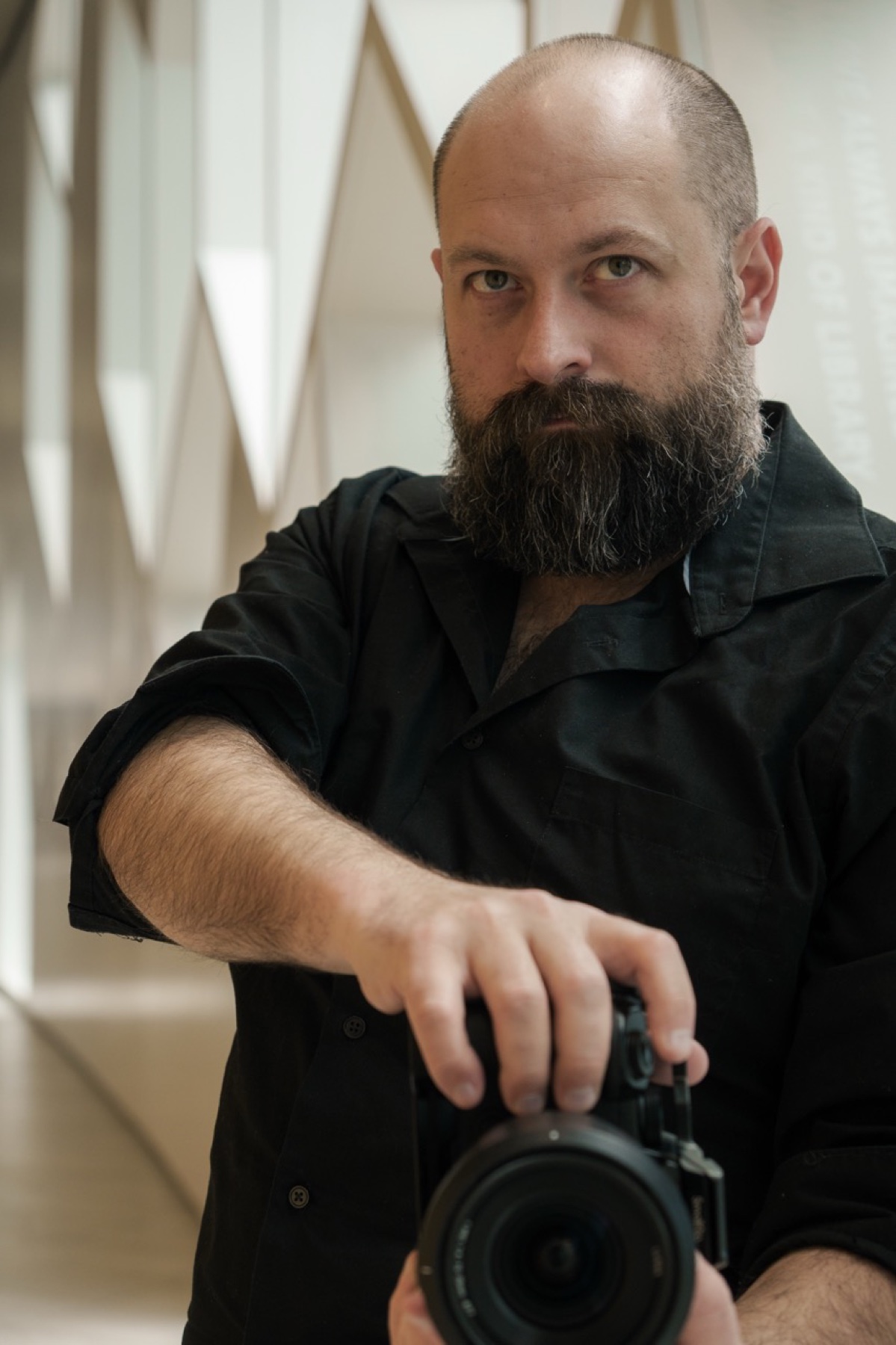 Kia holding a camera in a bright interior.