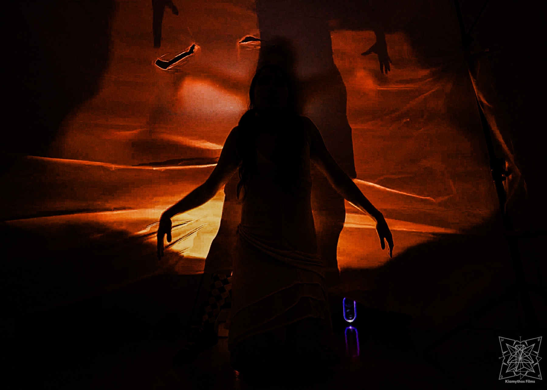 A silhouetted body in front of red and violet projection light.