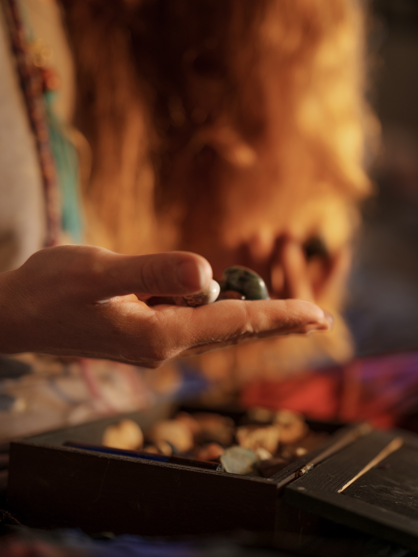 A close image of small objects held over a case in warm light.