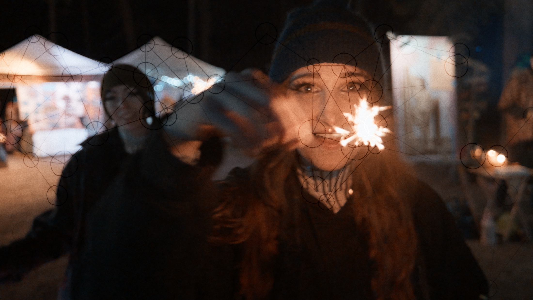 A performer holding a sparkler close to the lens at night.