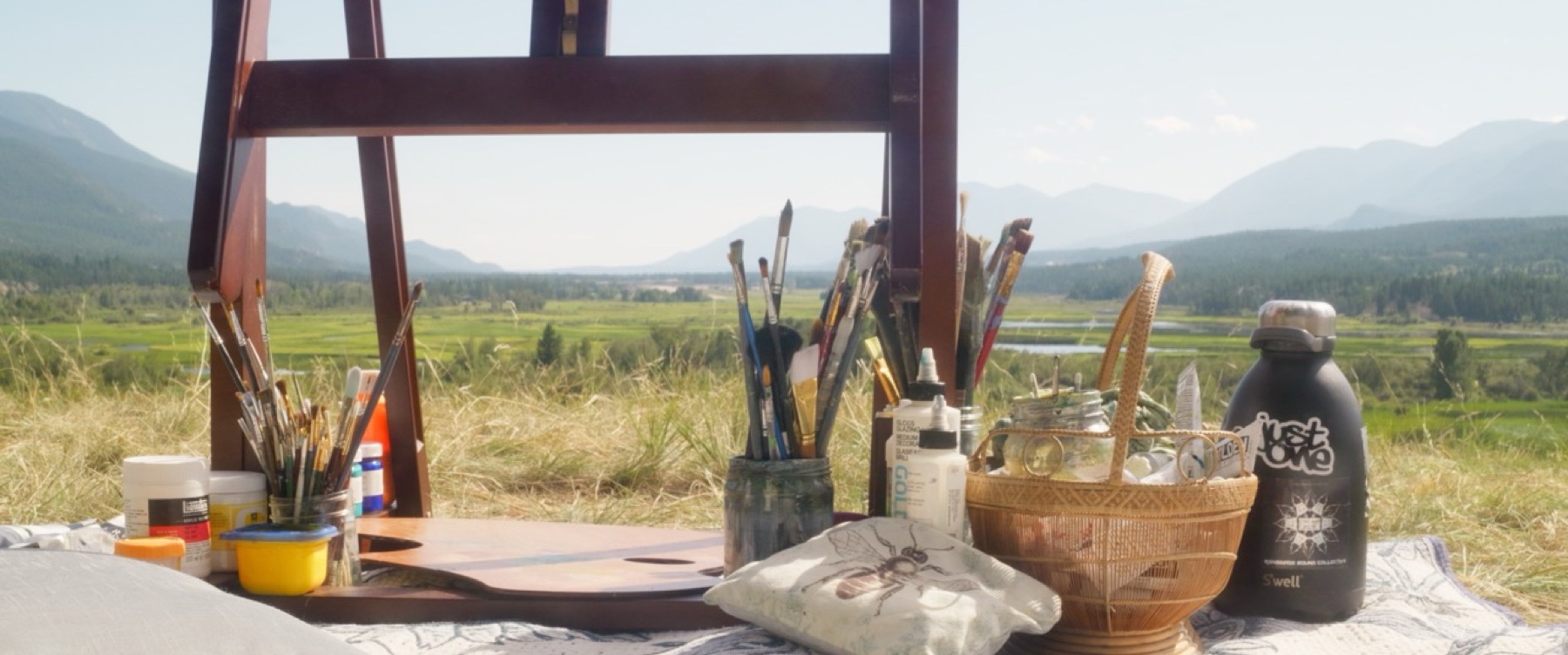 Art supplies arranged in a mountain landscape at Wicked Woods.