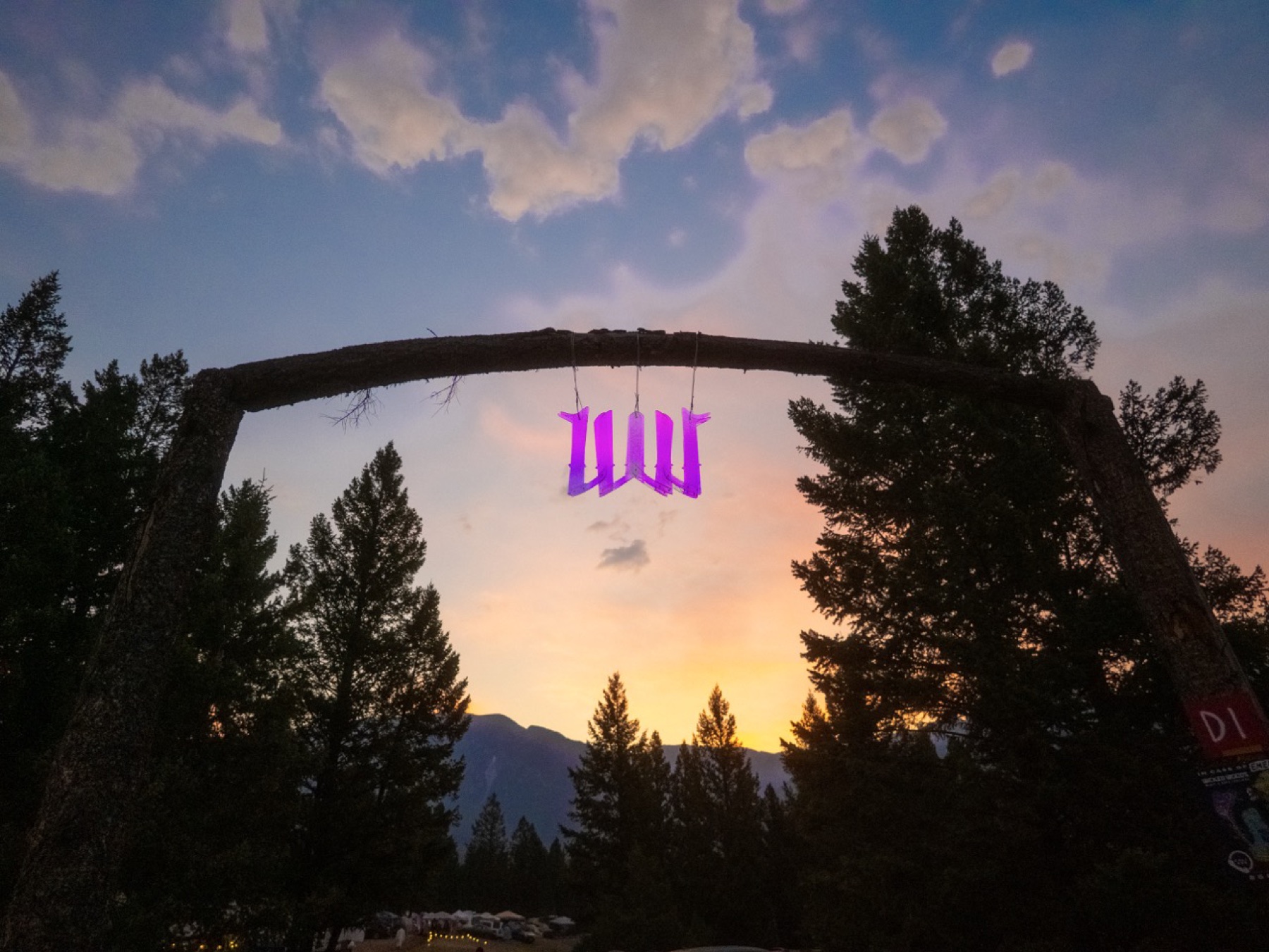 Wicked Woods entrance arch at sunset with a purple sign.